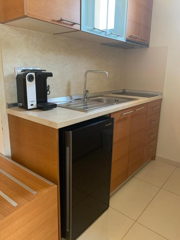 a small kitchen with a sink and a microwave at Vergos Hotel in Vourvourou