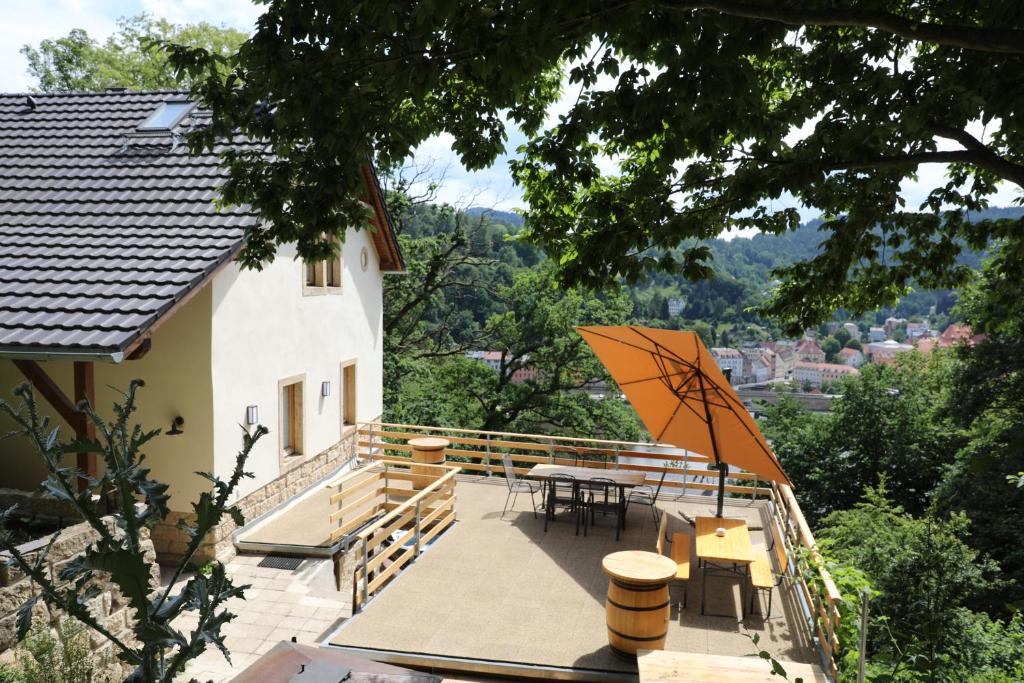 a patio with a table and an umbrella at Luxusboofe - Ferienhaus am Lilienstein in Königstein an der Elbe