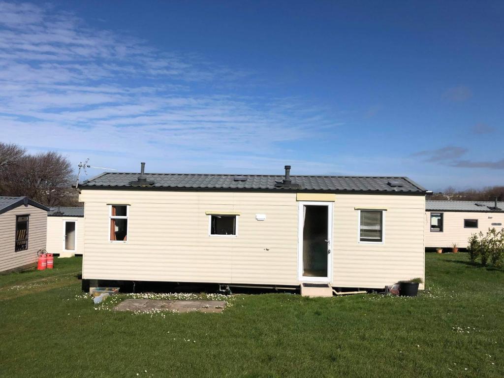una casa bianca con un tetto nero in un cortile di Kernow Wishes a Newquay