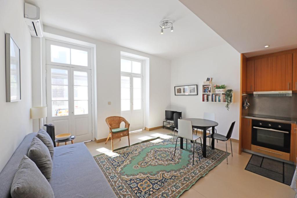 ein Wohnzimmer mit einem Sofa und einem Tisch in der Unterkunft FLH Porto City Apartment with Balcony in Porto