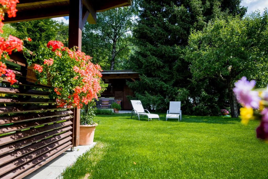 a garden with two chairs and flowers on the grass at Hotel Montfort in Sankt Anton am Arlberg