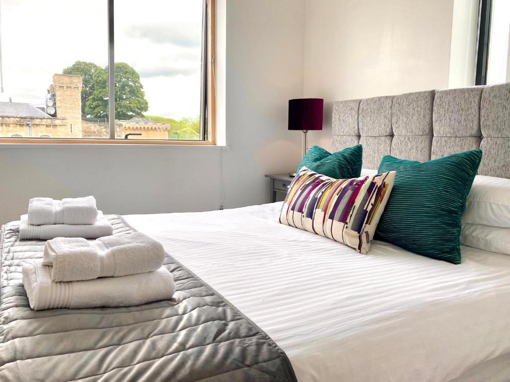 a bedroom with a large bed with pillows and a window at Oxford Castle Apartments in Oxford