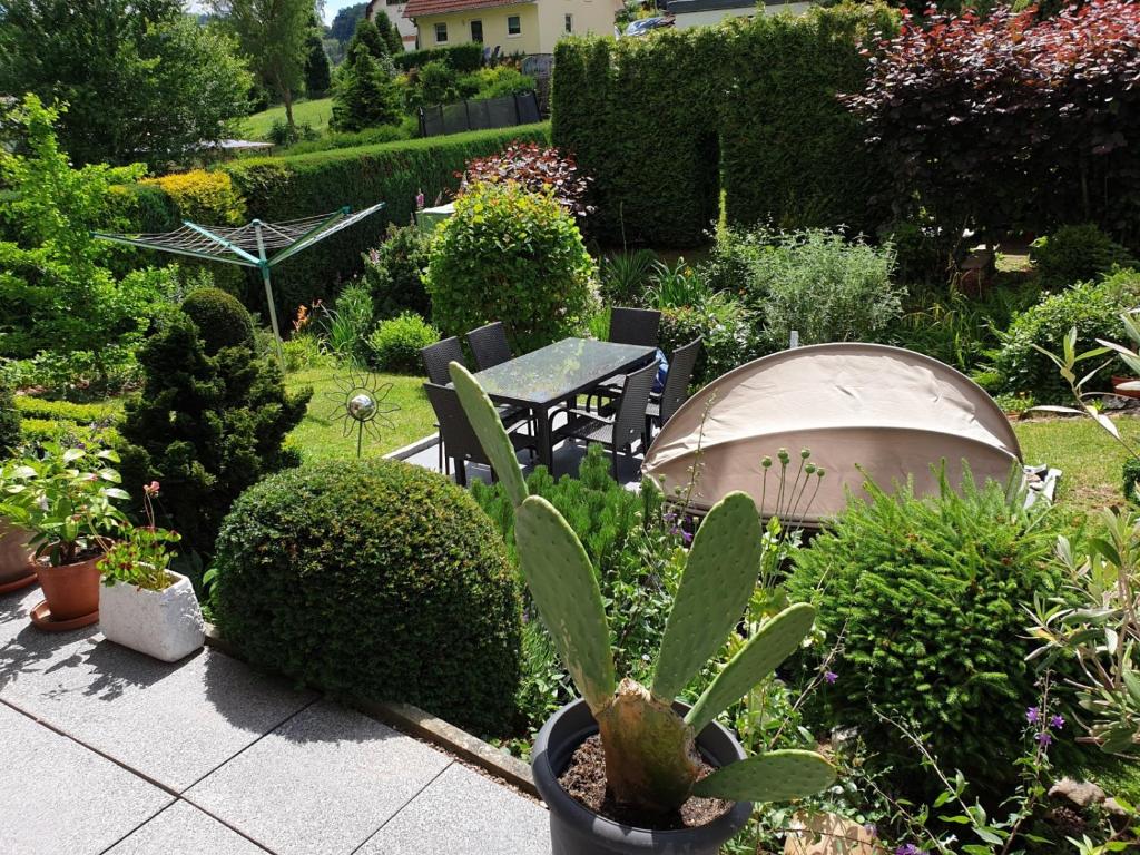 un jardín con mesa, sillas y plantas en Zum Himmelreich, en Wutha-Farnroda