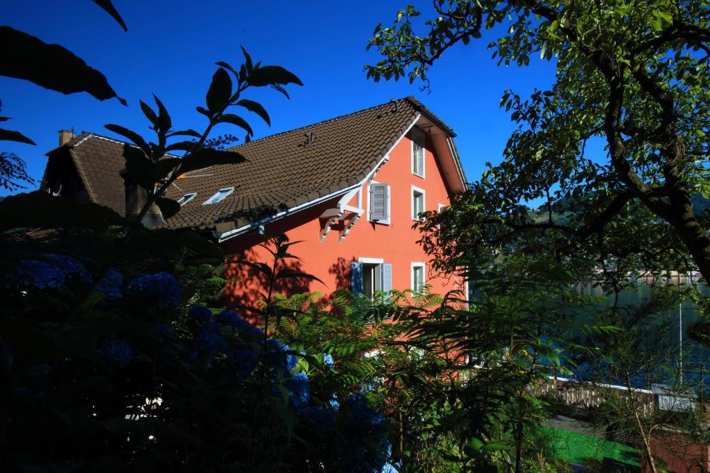 a red house seen through the trees at Zappa Lake Lodge in Brusino Arsizio