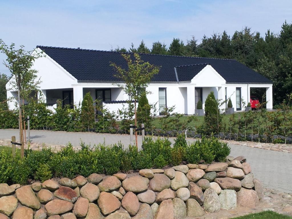 une maison blanche avec un toit noir dans l'établissement Bed & Breakfast Ribe, à Ribe