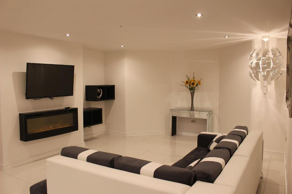 a living room with a couch and a tv at Blossom lane in Woodford