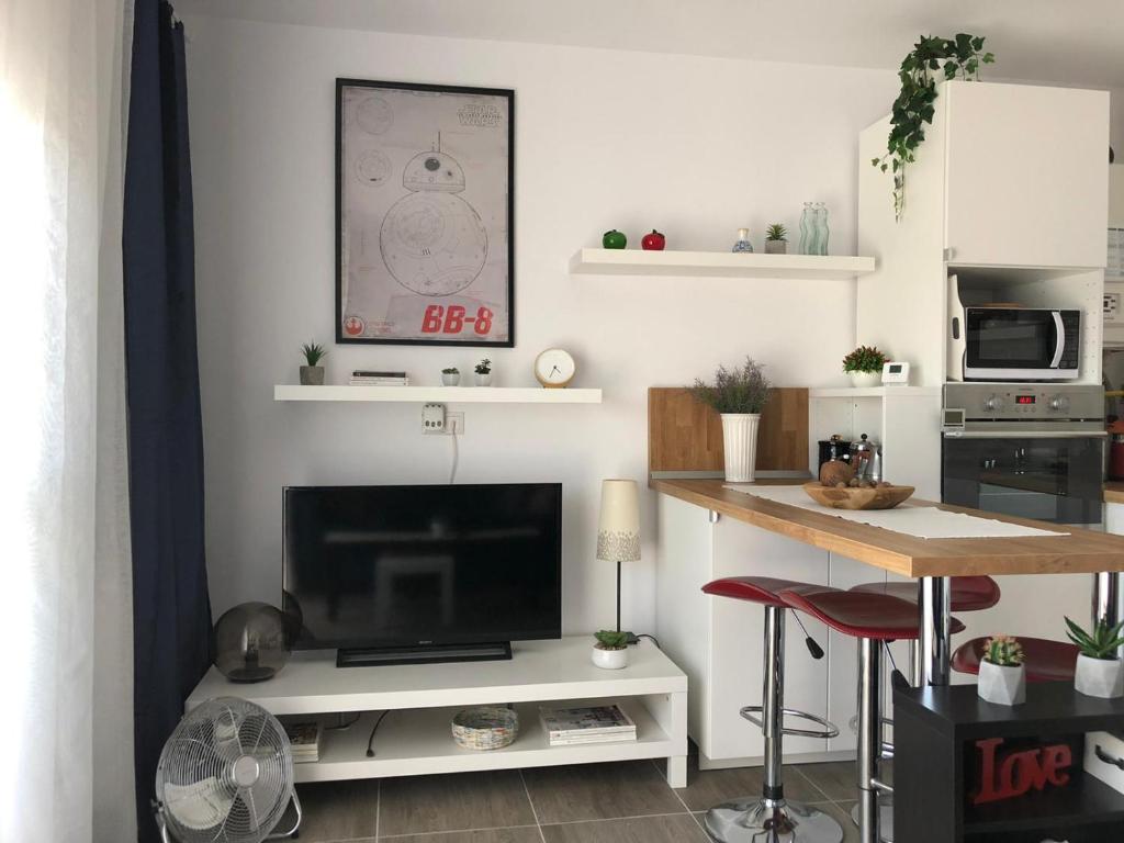 sala de estar con TV y barra con mesa en Sunset apartment, en Bistriţa