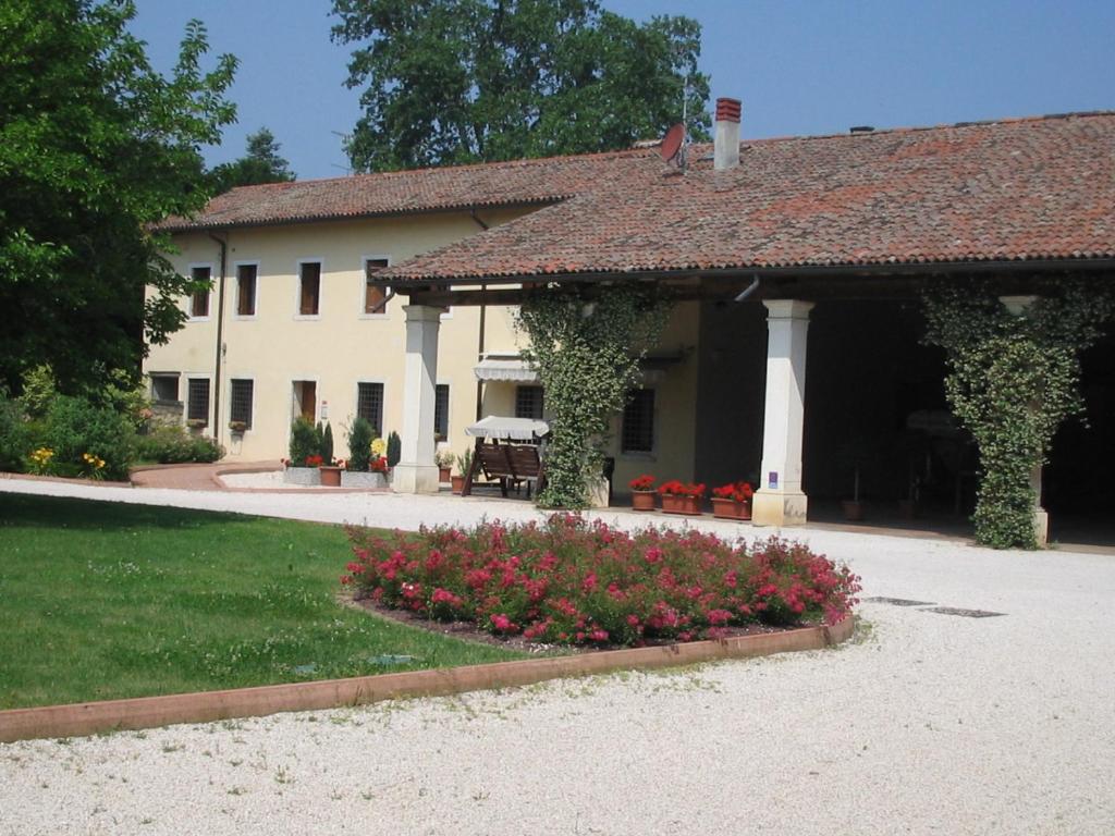 a house with a garden with flowers in front of it at Fattoria Villa Curti in Sovizzo