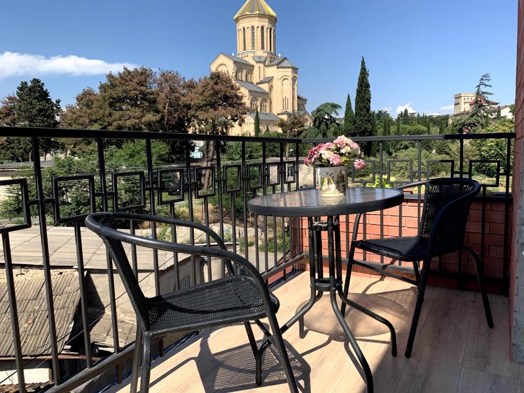 un tavolo e sedie su un balcone con vista su una chiesa di SaBa Apartments in Old Tbilisi a Tbilisi City