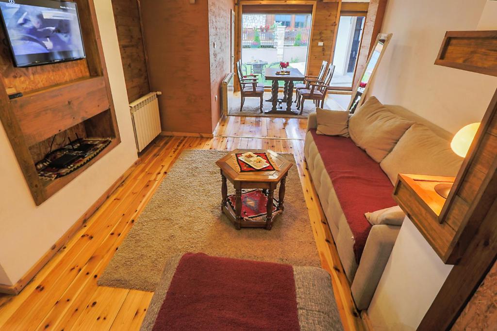 ein Wohnzimmer mit einem Sofa und einem Tisch in der Unterkunft Apartments Tango in Kolašin