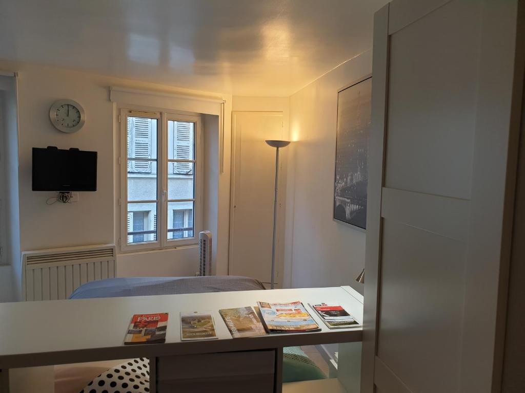 a small room with a table and a window at Le centre Fontainebleau in Fontainebleau