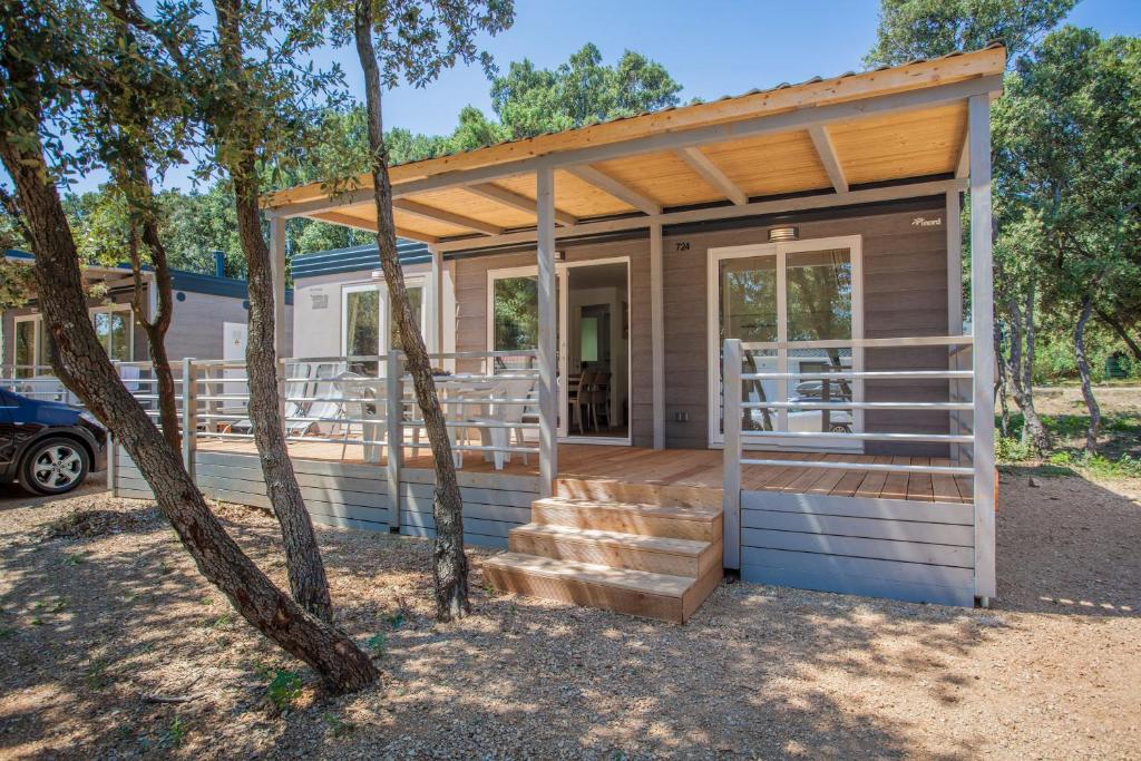 een tiny house met een veranda en een trap bij Mobile Homes Delta Marine at Campsite Lopari in Nerezine