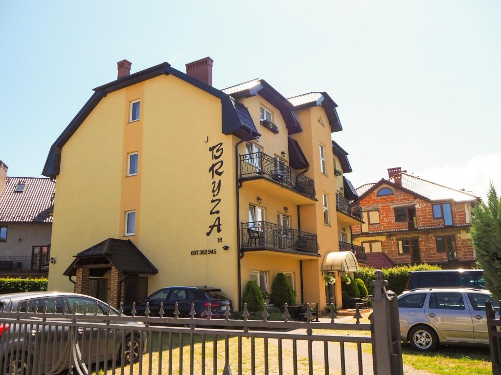 a yellow building with writing on the side of it at Pensjonat Bryza in Karwia