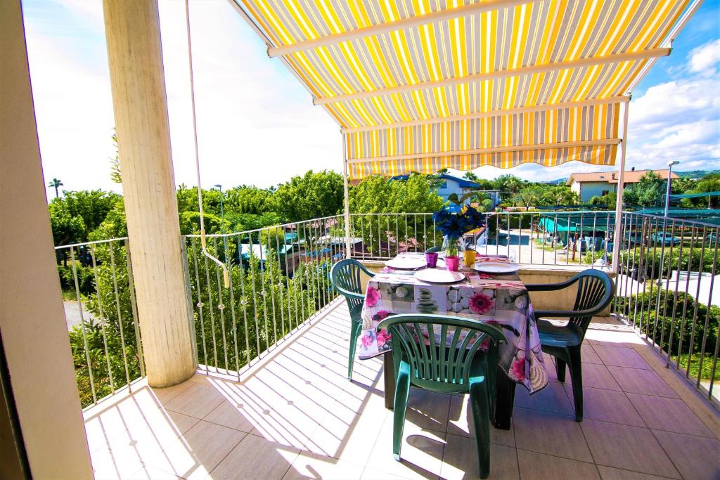 einen Tisch und Stühle auf einem Balkon mit Tisch und Stühlen in der Unterkunft Accogliente Trilocale Turone a due passi dal mare in Martinsicuro