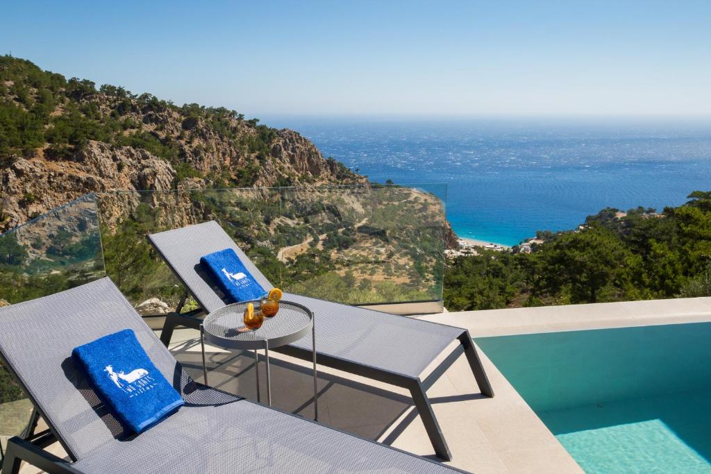 duas cadeiras e uma mesa com vista para o oceano em Two Goats Villas em Kyra Panagia