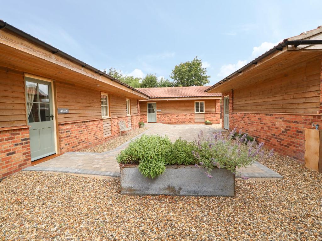 a brick building with a door and a courtyard at Golson Stable in Spalding