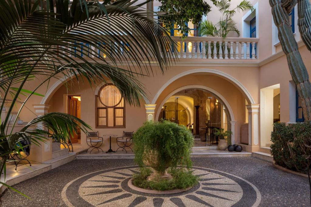 einen Innenhof mit einer Palme in einem Gebäude in der Unterkunft Casa Delfino Hotel & Spa in Chania