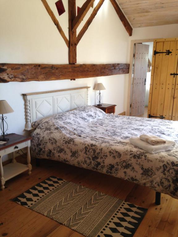 a bedroom with a bed and a wooden floor at Chambres d'hotes des Forets in Écuras