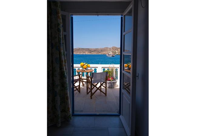 a balcony with a table and a view of the water at Katapola Vekris apartments in Katapola