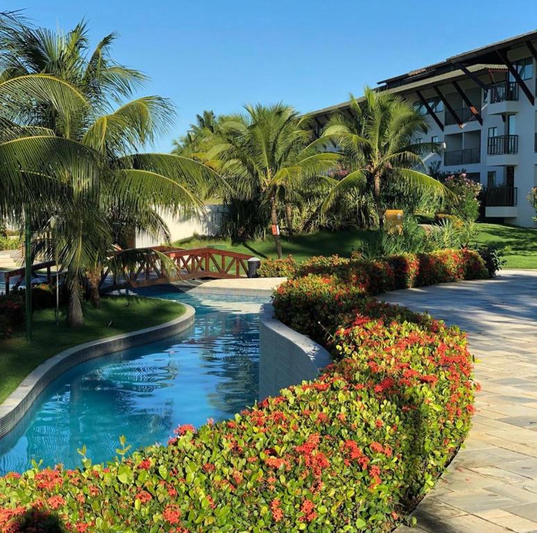 ein Resort mit einem Pool und Blumen in der Unterkunft Beach Class Slin Muro Alto in Porto De Galinhas