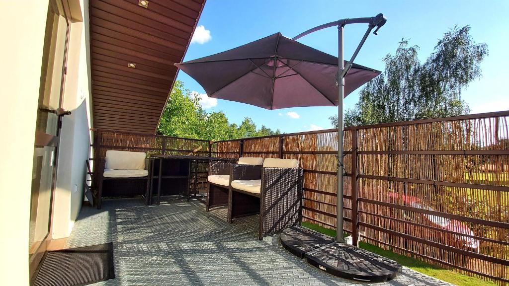 patio con ombrellone su una recinzione di Agroturystyka KRAINA JEZIOR a Ludwin