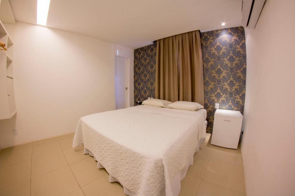 1 dormitorio con 1 cama blanca en una habitación en Vivaz Boutique Hotel, en Recife