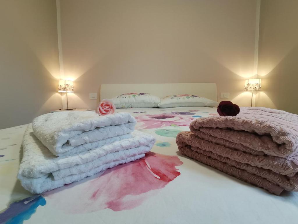a bed with a pile of blankets and pillows on it at Apartma VRTNICA in Bovec