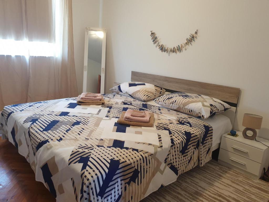 1 dormitorio con cama con edredón y espejo en Apartment Boomerang, en Ražanac