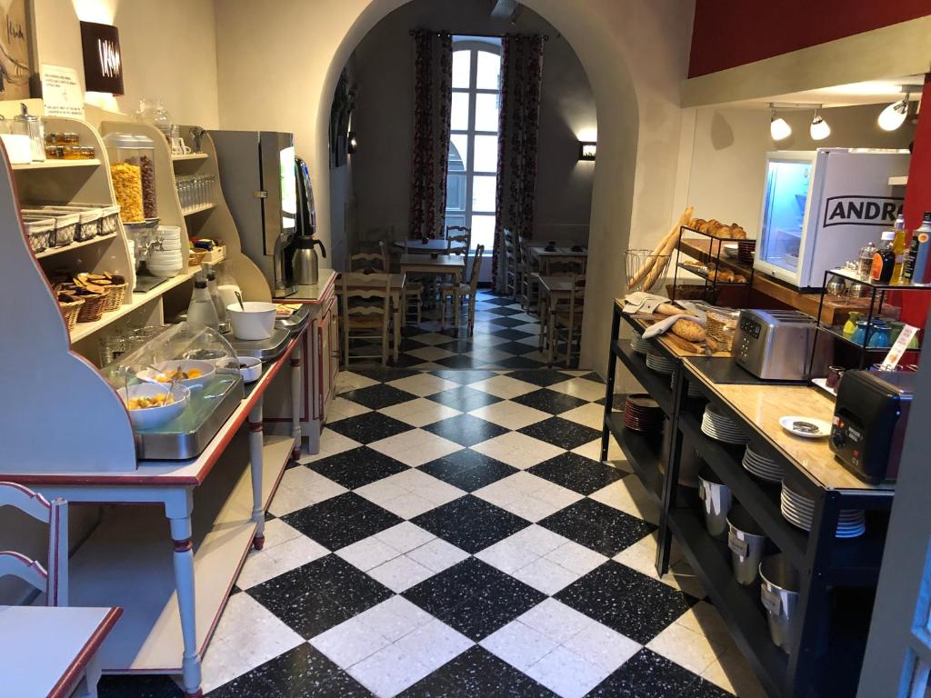 una cucina con pavimento a scacchi in bianco e nero di Hôtel du Musée a Arles