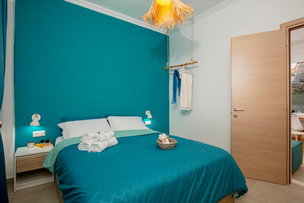 a blue bedroom with a bed with a blue wall at Rilassunte Luxury apartments in Potos