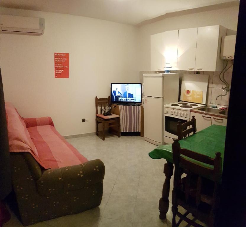 Sala de estar con cocina con sofá y TV en Apartments Nena, en Split