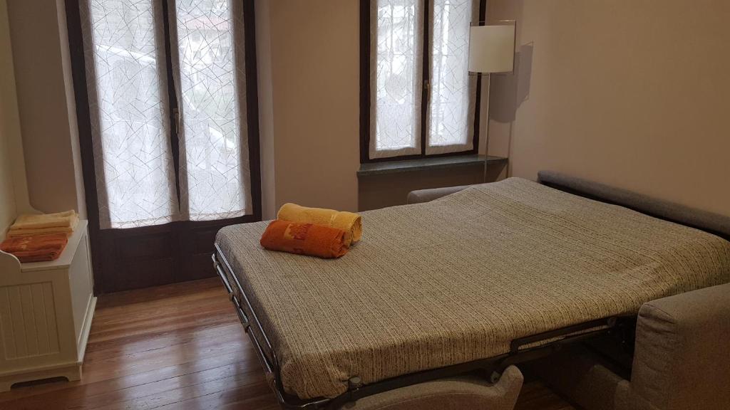 un piccolo letto in una camera con due finestre di La Ca' d' Rina Casa Vacanze a Melle