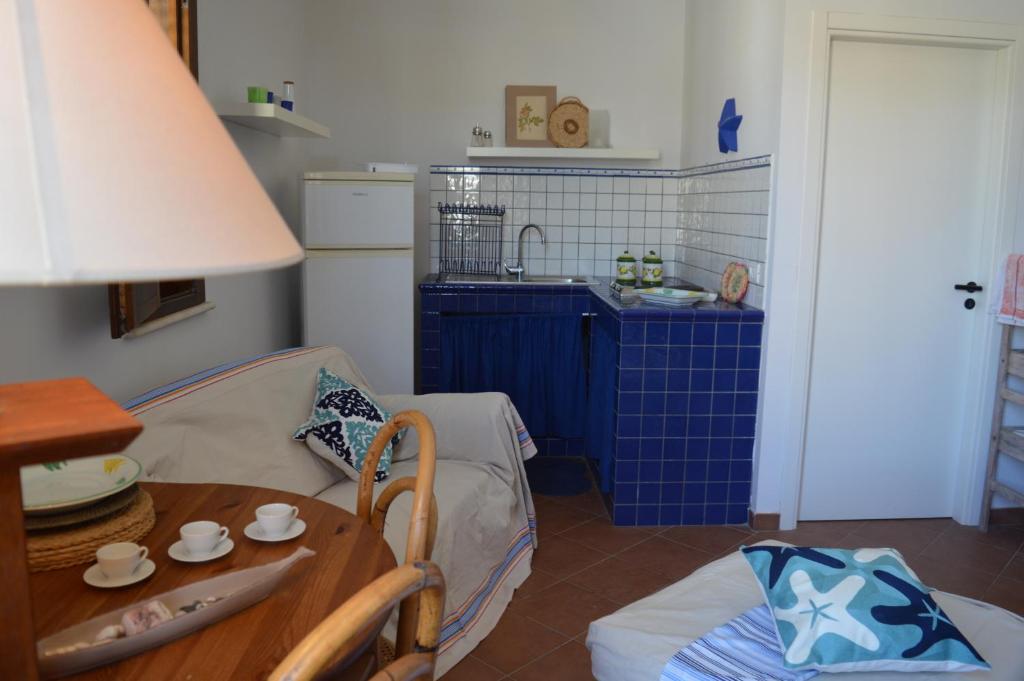 a room with a table and a kitchen with blue tiles at Casa Blue in Favignana