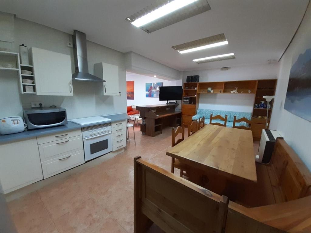 una cucina con tavolo in legno e una sala da pranzo di La SUCURSAL a Cazalegas