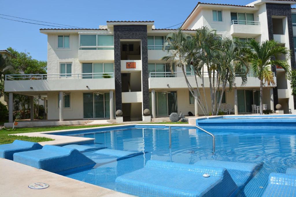 una piscina frente a un edificio en Zenharmony Suites en Puerto Vallarta