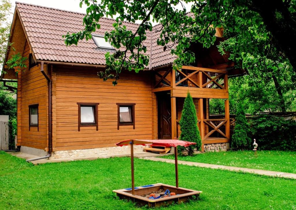 a wooden house with a table in the yard at Файна Хижа in Mizhhirʼʼya