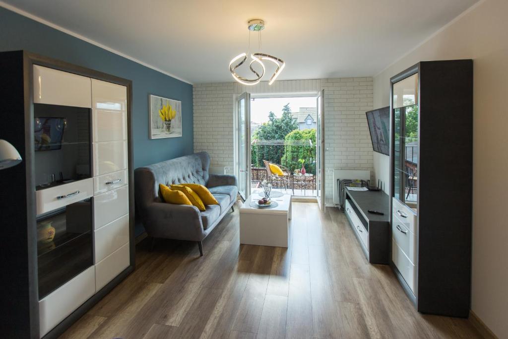 un salon avec un canapé et une télévision dans l'établissement Apartament u Violetty, à Łeba