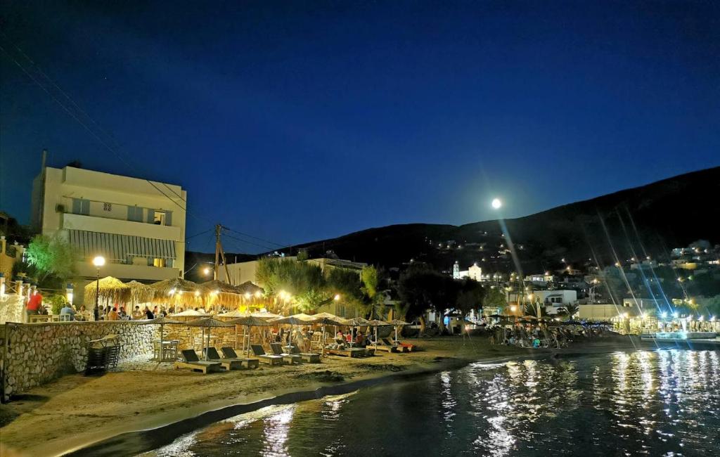 grupa ludzi siedzących na plaży w nocy w obiekcie Venerdi Libero w mieście Kini