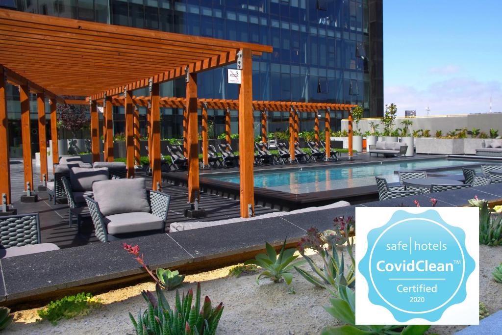 um pavilhão com cadeiras e uma piscina em frente a um edifício em QUARTZ HOTEL & SPA em Tijuana