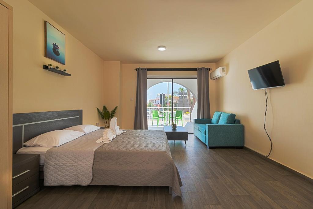 1 dormitorio con 1 cama, TV y silla en Leucolla Hill & Sea, en Protaras