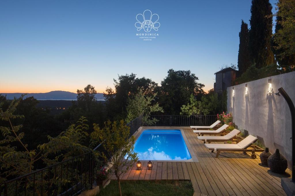 einen Hinterhof mit einem Pool und Liegestühlen in der Unterkunft Mondinica Heritage House in Dobrinj