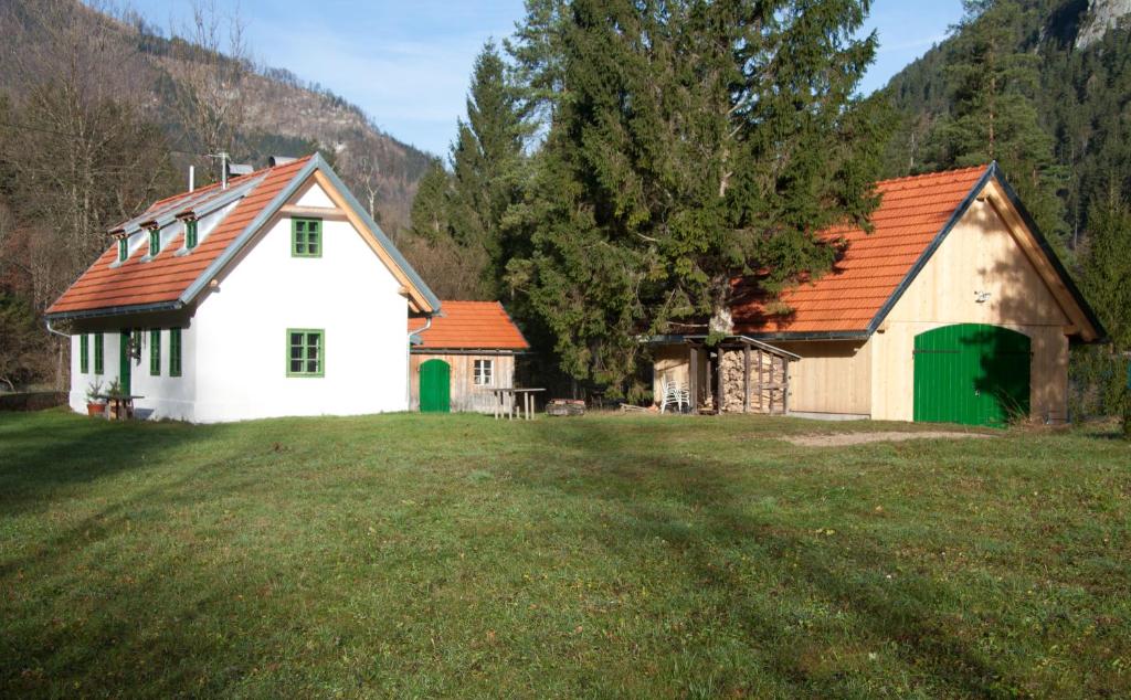 a white barn with a red roof on a field at STEYR RIVER LODGE in Hinterstoder