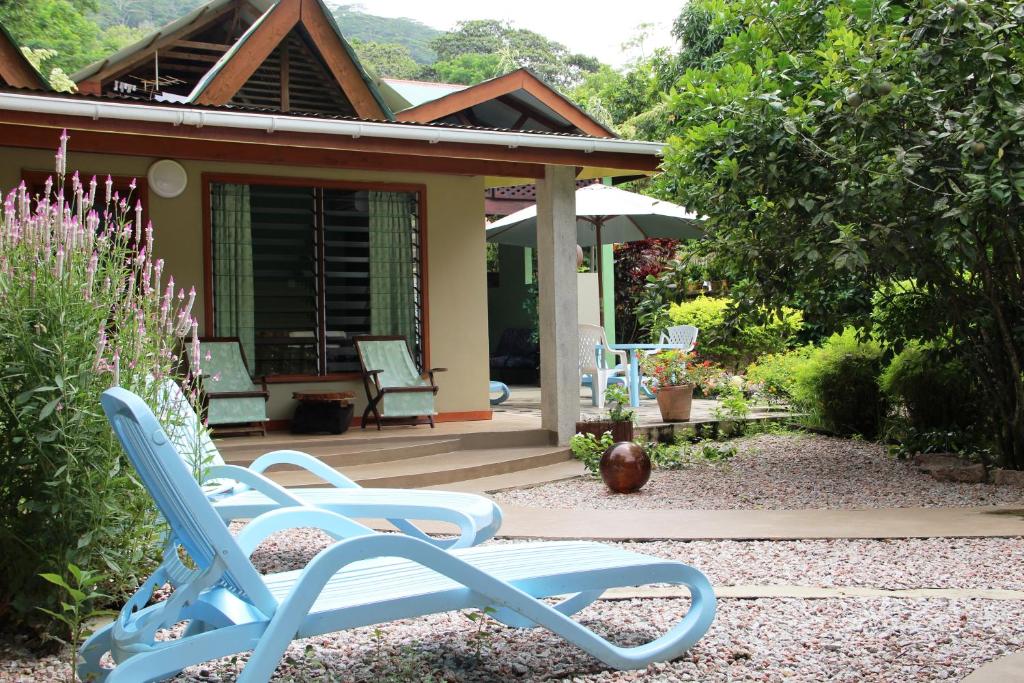 a group of blue chairs in front of a house at Belle Des Iles in La Digue