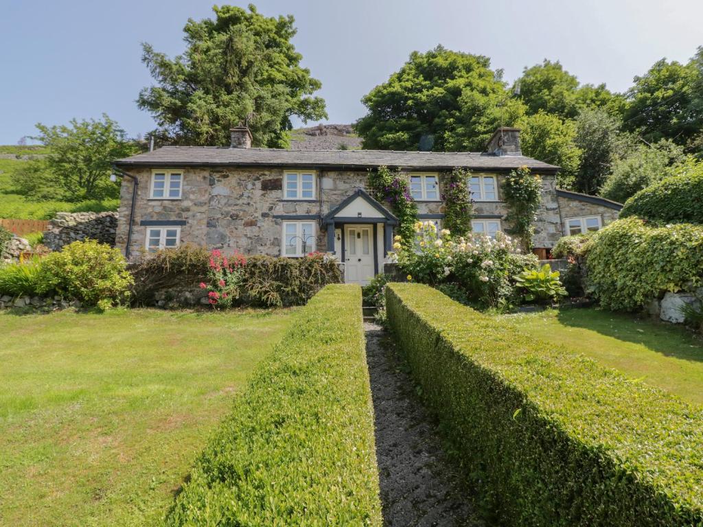 an old stone house with a garden in front of it at Haulfryn in Llangynog