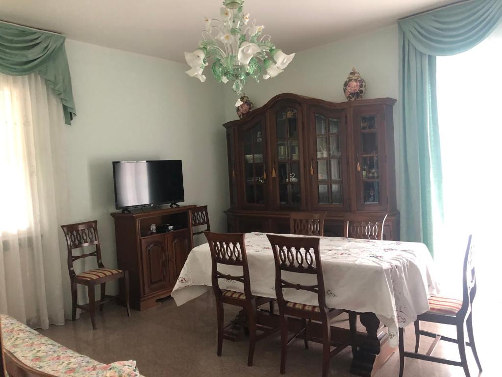 una sala da pranzo con tavolo, sedie e TV di Villa alle Marixe ad Albenga