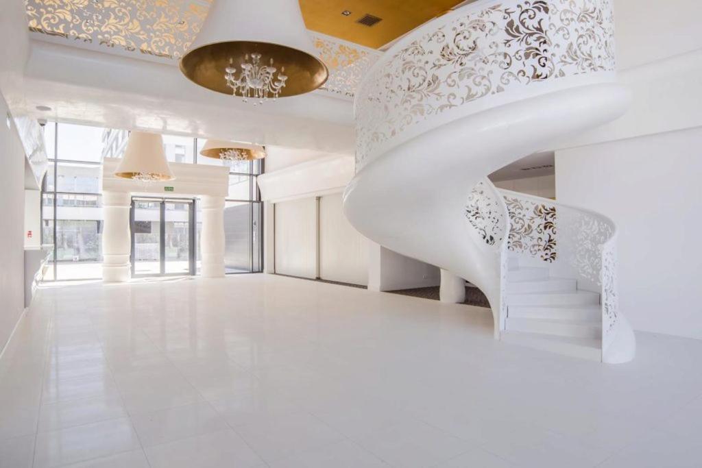 a white staircase in a building with a chandelier at Dune B Apartment in Mielno