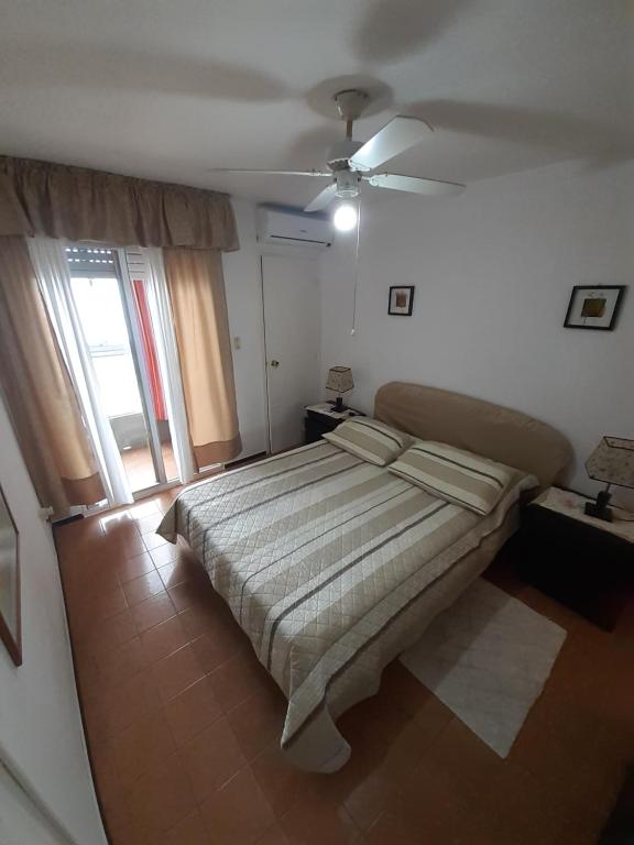 a bedroom with a bed and a ceiling fan at Al Mar in Piriápolis