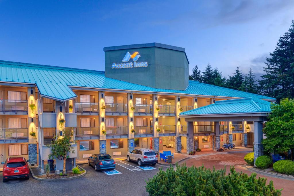 a hotel with cars parked in a parking lot at Accent Inns Kelowna in Kelowna