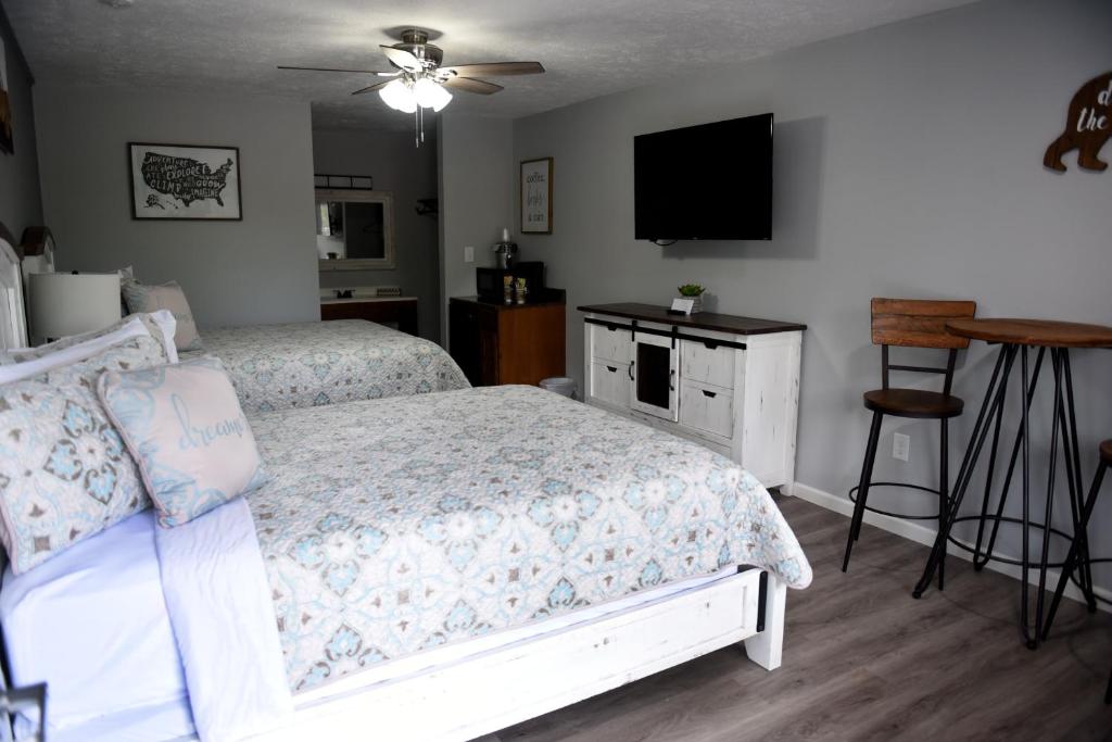 a bedroom with a bed and a flat screen tv at Heidi Motel - Helen in Helen
