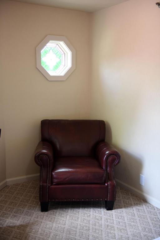 a brown leather chair in a corner with a window at Heidi Motel - Helen in Helen